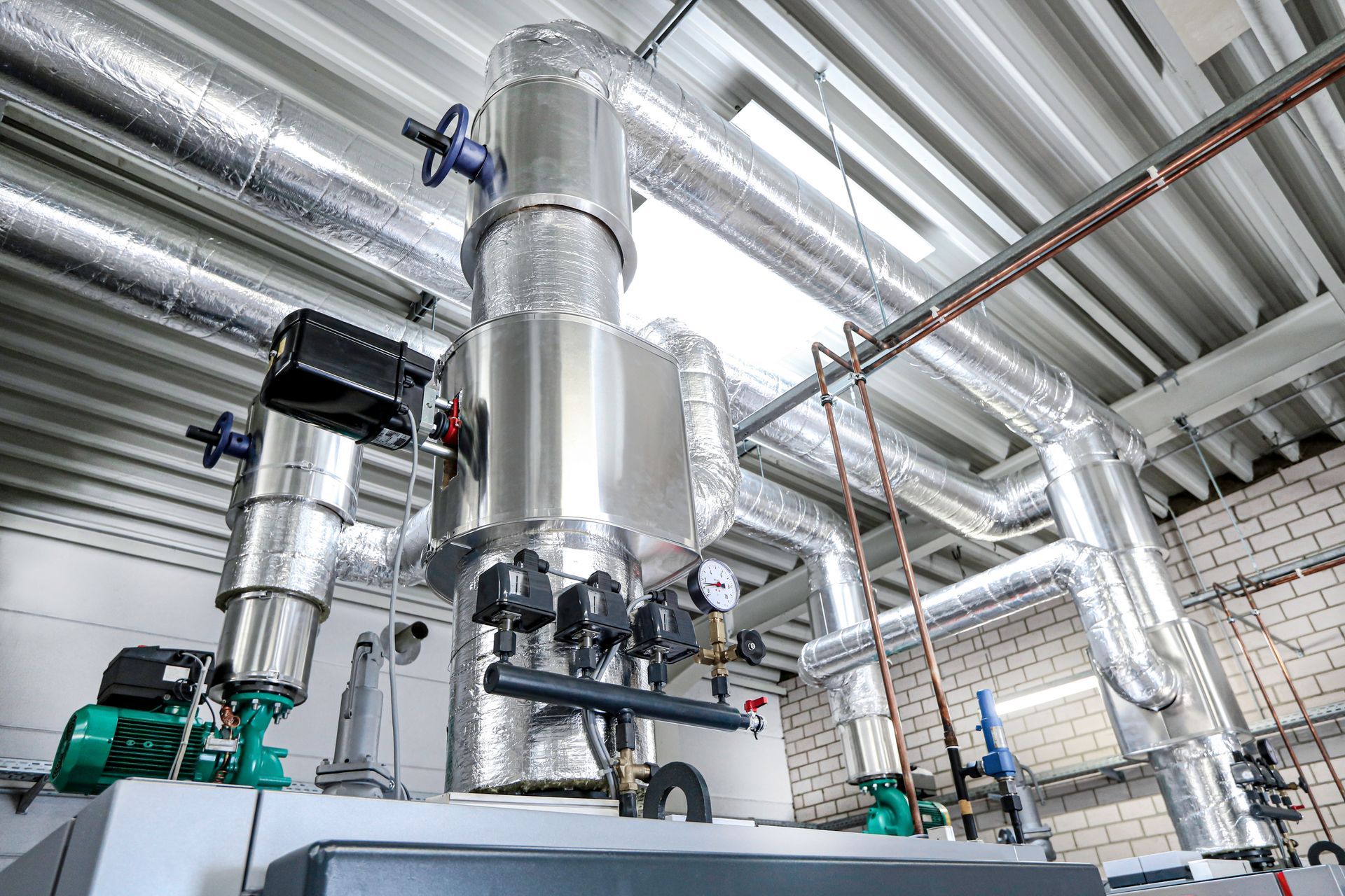 A residential water heater, humidifier, and furnace. Gray and silver appliances in a utility room.