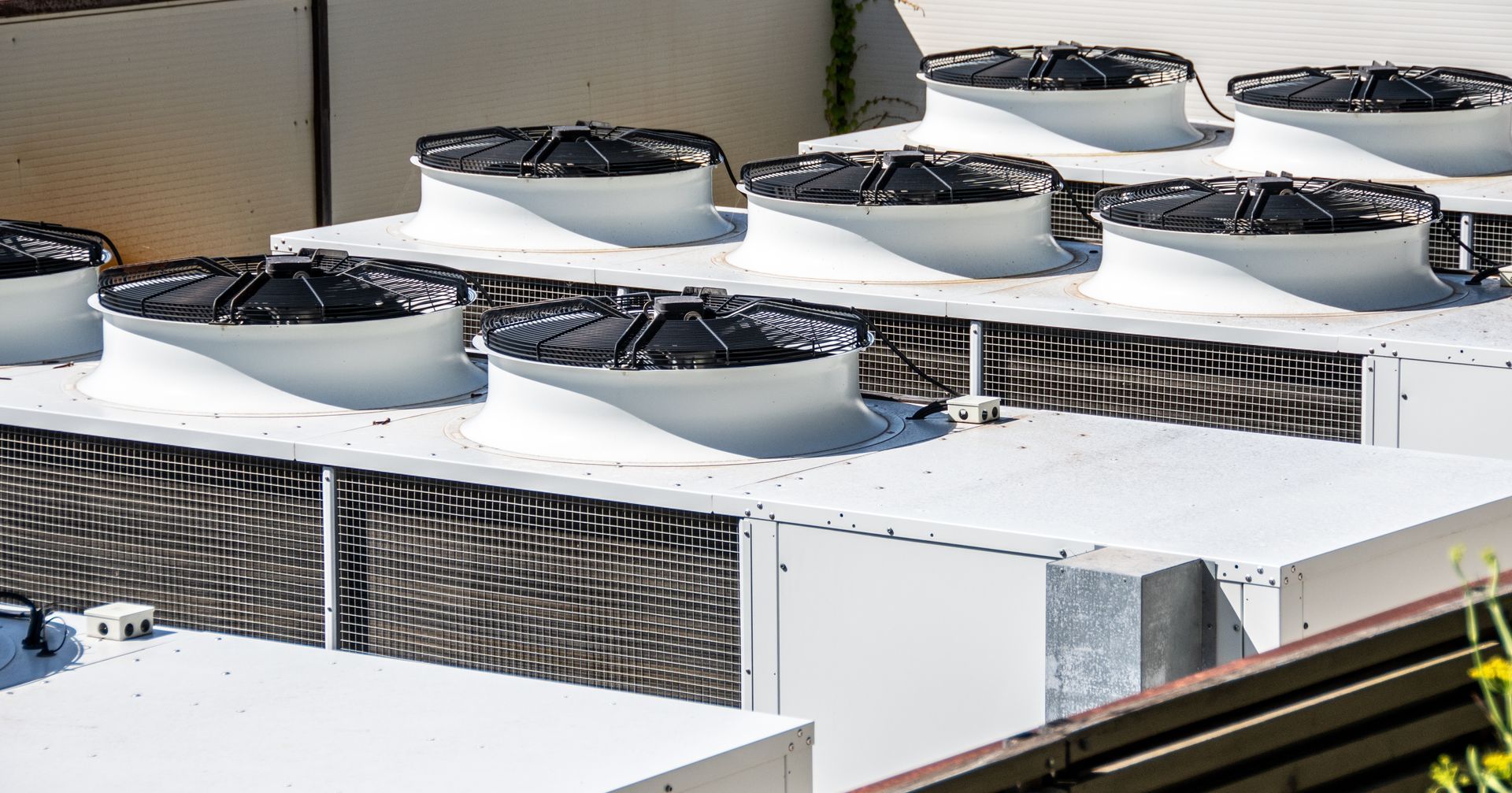 White rooftop HVAC units with black fan covers.