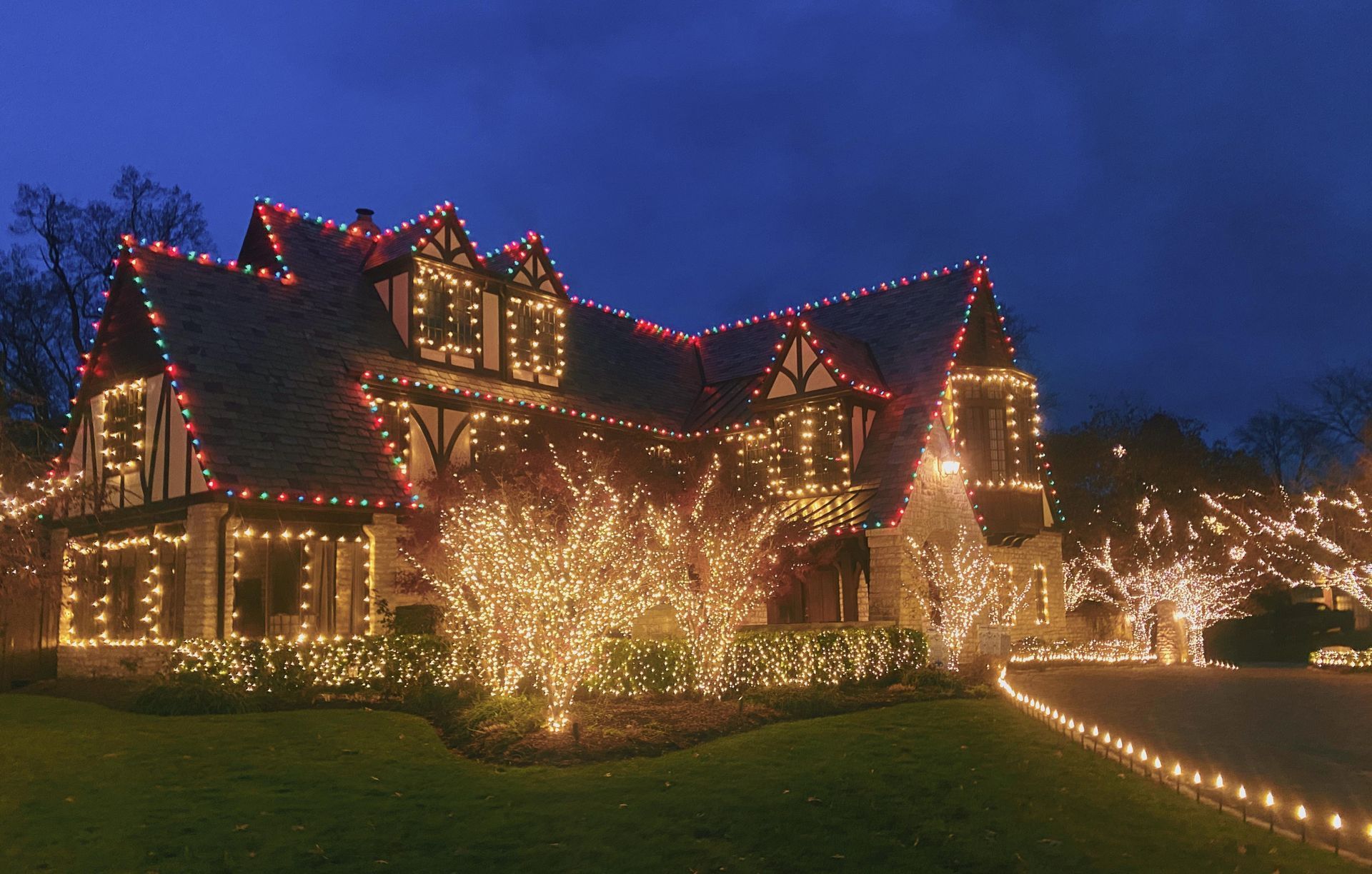 House decorated with red and white Christmas lights at night.