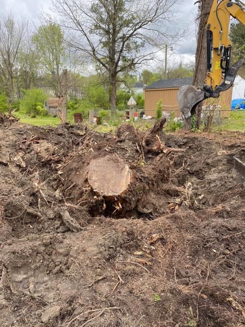 A large yellow excavator is demolishing a building.