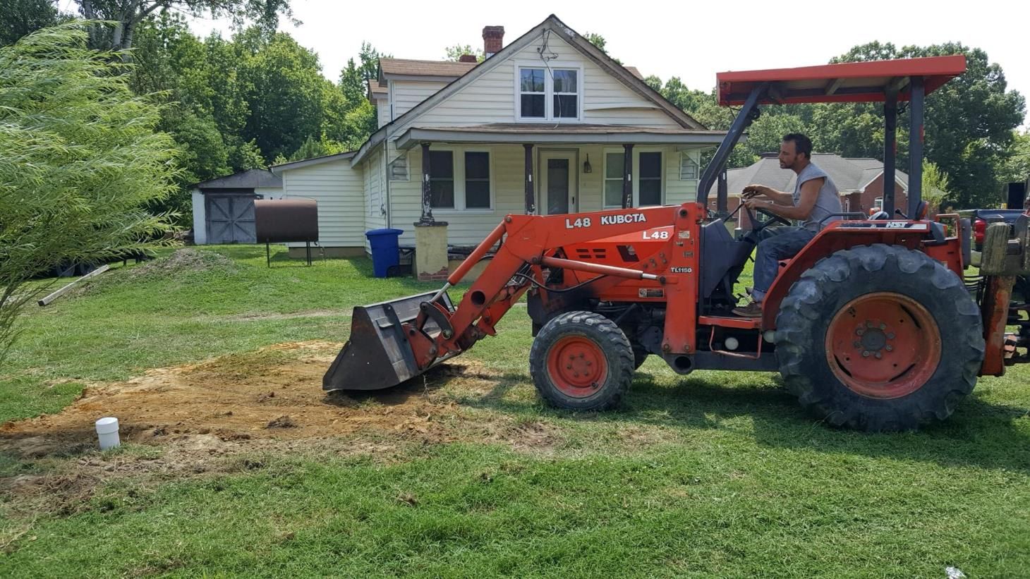 A bulldozer is demolishing a building with a large bucket.