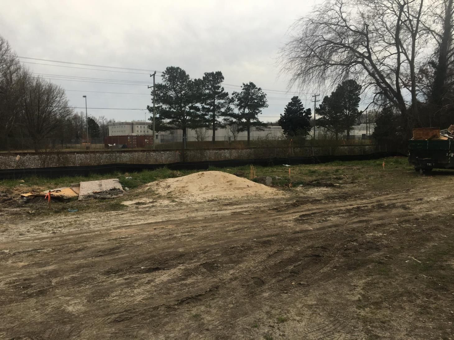 A large yellow excavator is demolishing a building.