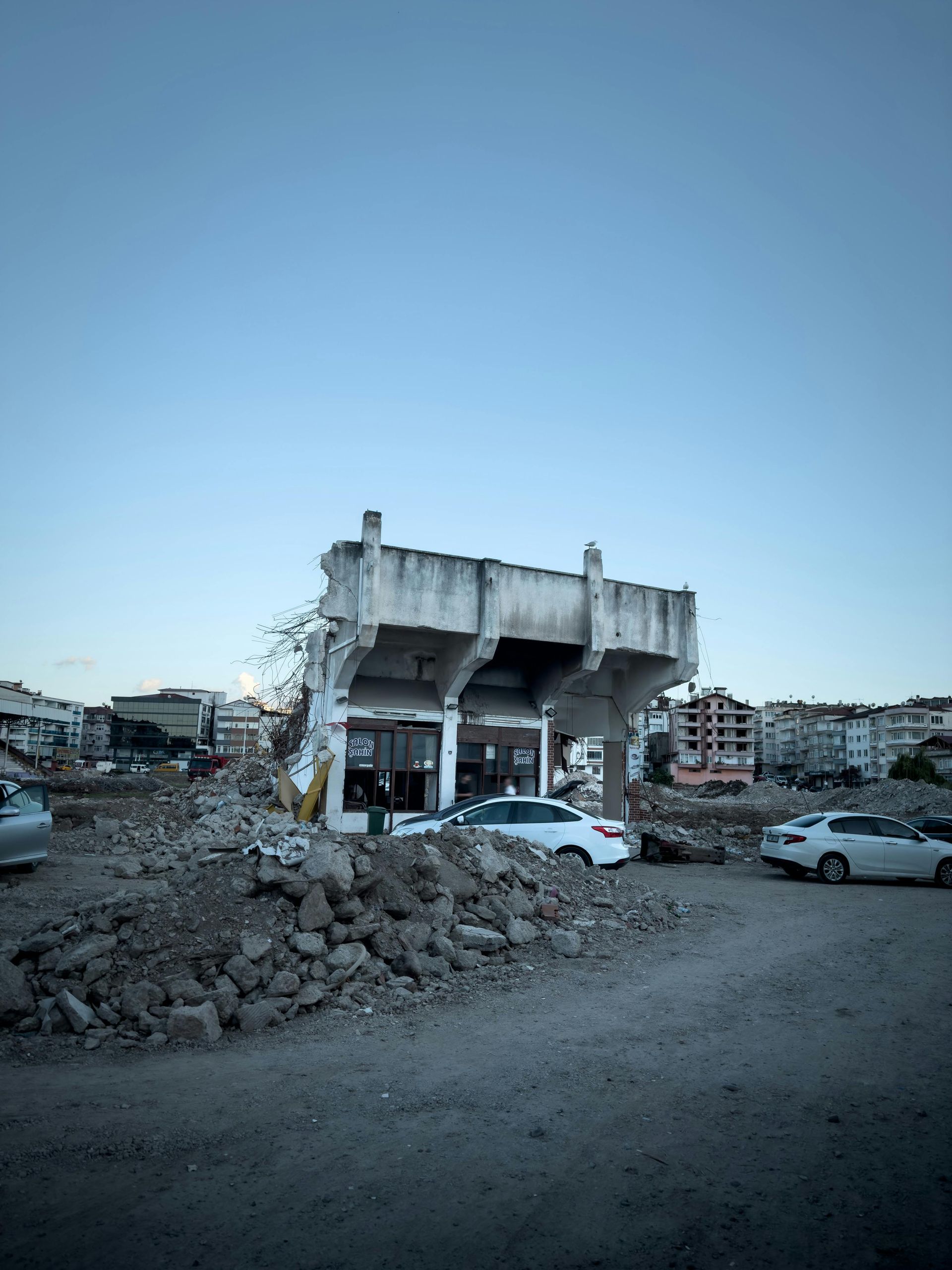 A large yellow excavator is demolishing a building.