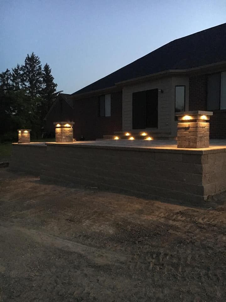 A brick wall with lights on it in front of a house