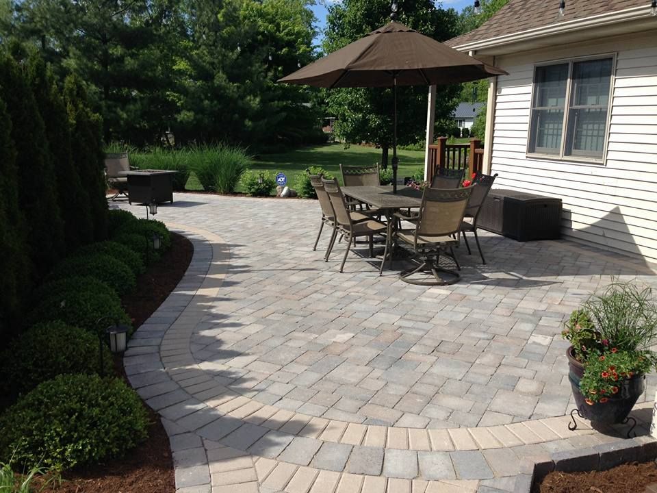 A patio with a table and chairs under an umbrella