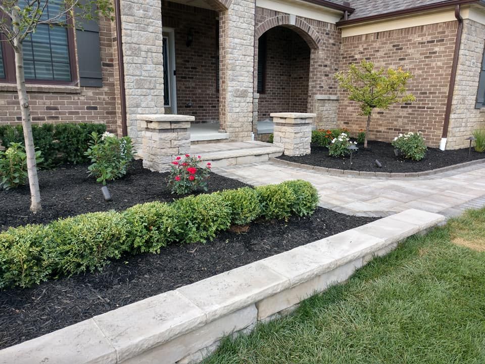 A brick house with a walkway leading to the front door.