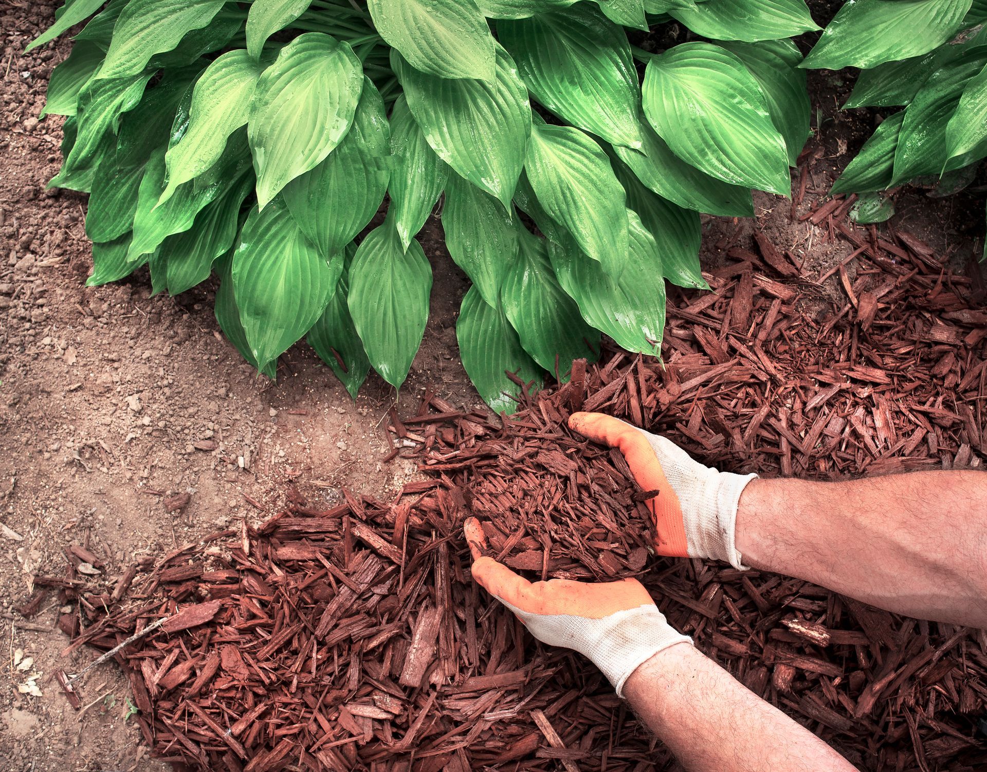A man is building a stone wall with his hands.