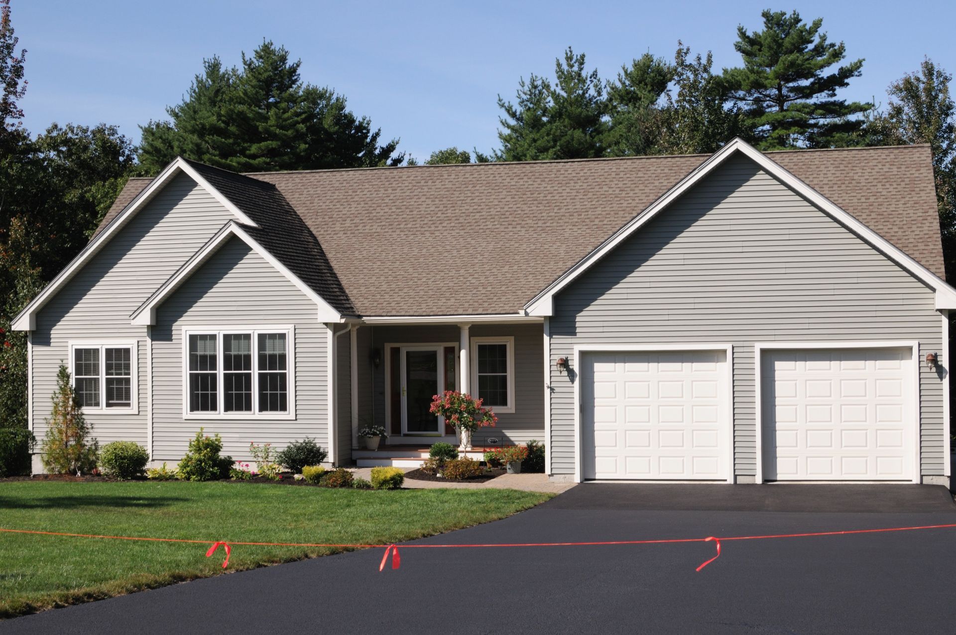 A large house with two garage doors and a driveway