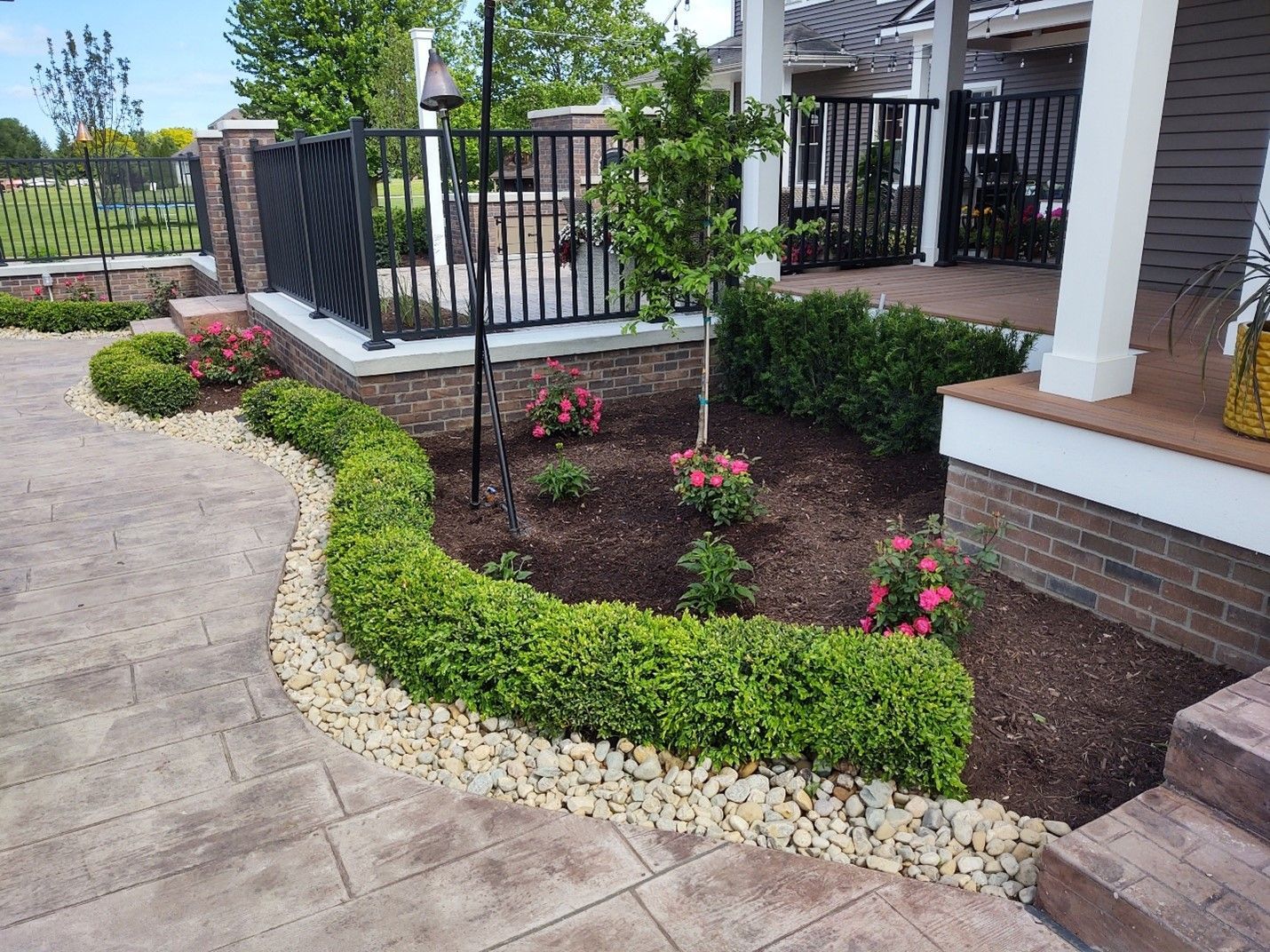 A garden with flowers and bushes in front of a house.