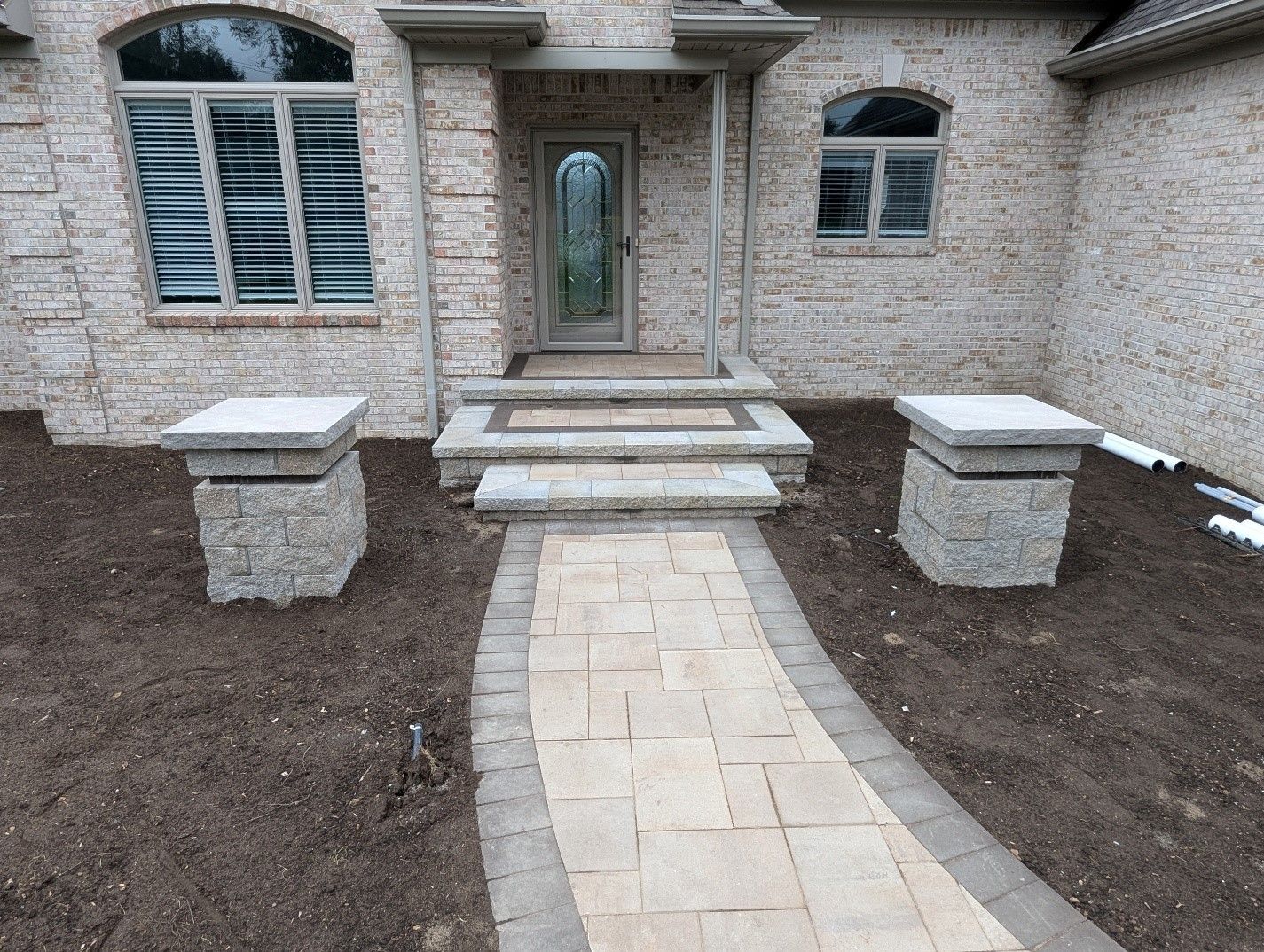 A brick walkway leading to the front door of a house.