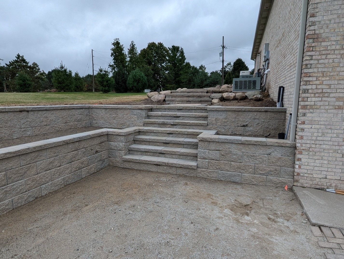 A stone wall with stairs leading up to a house.