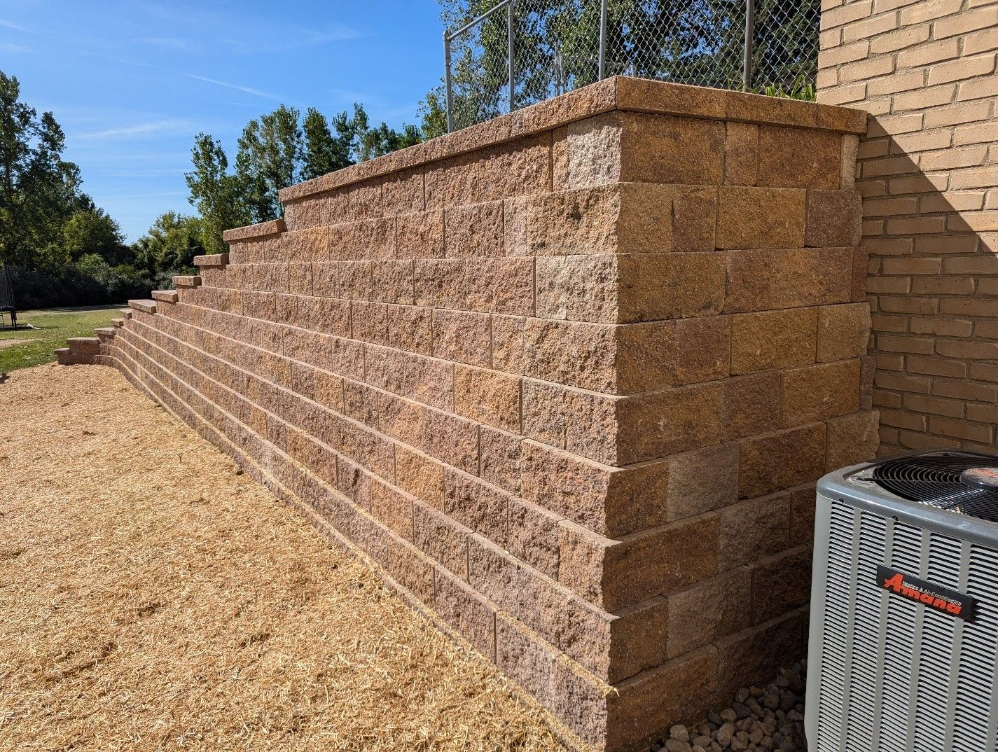 A brick wall with a air conditioner next to it.