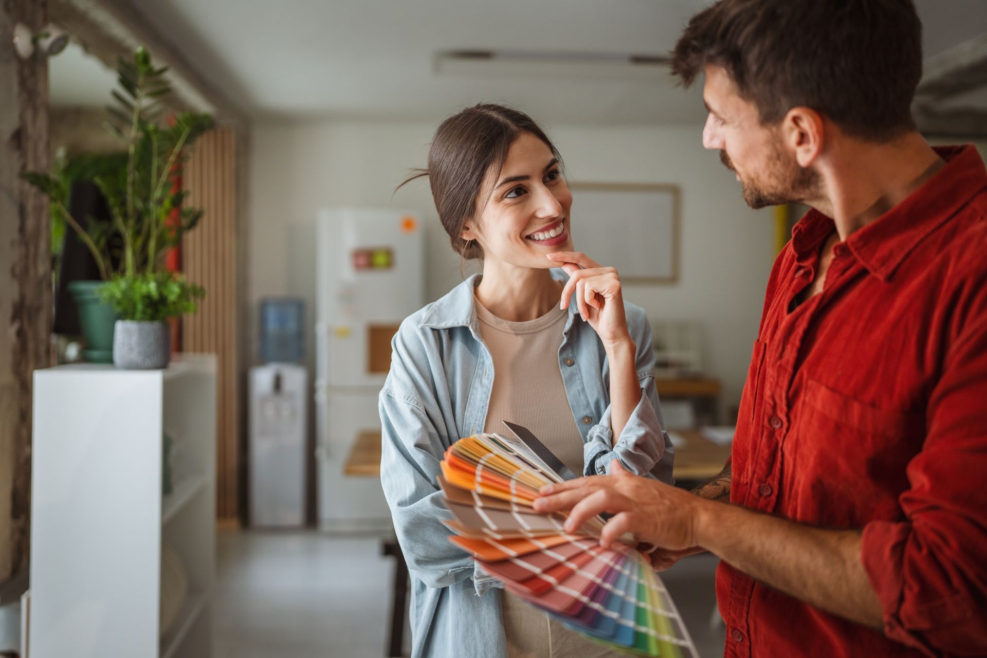 Two people discussing color swatches in a home interior setting.