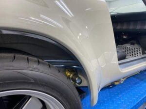 A close up of a car 's fender and tire on a blue table.