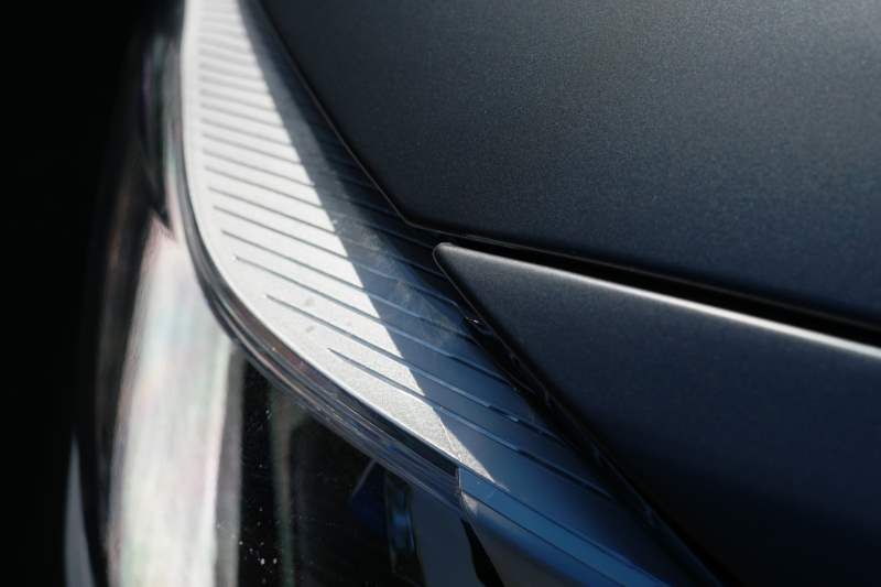 A close up of a car 's headlight on a black background.