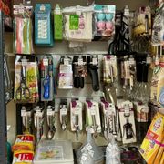 A variety of kitchen utensils are hanging on a wall in a store.