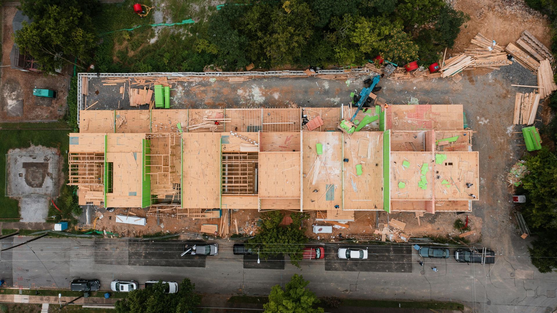 An aerial view of a wooden townhouse construction site with exposed framing.