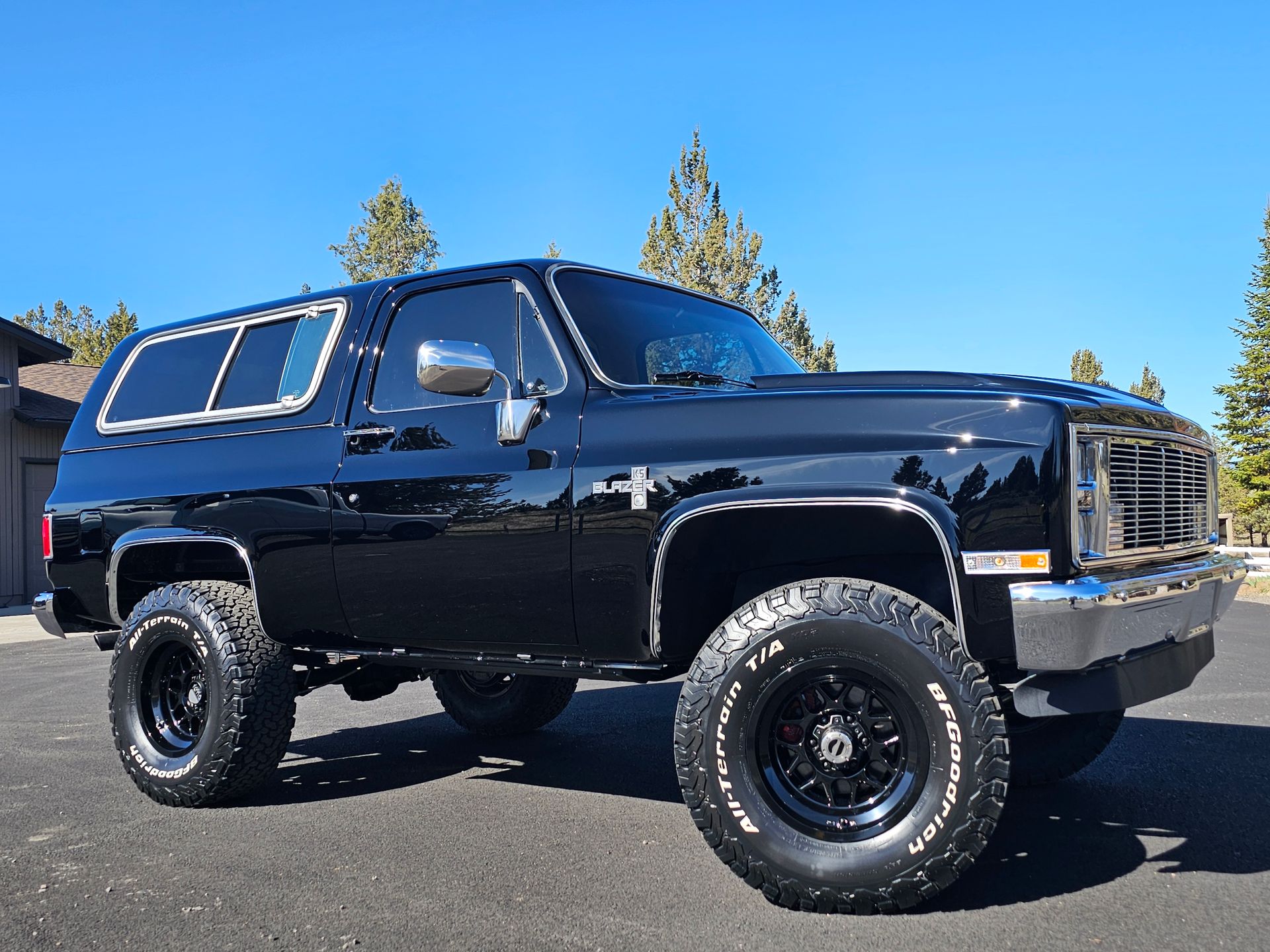Black vintage Chevy Blazer SUV parked outdoors on sunny day.