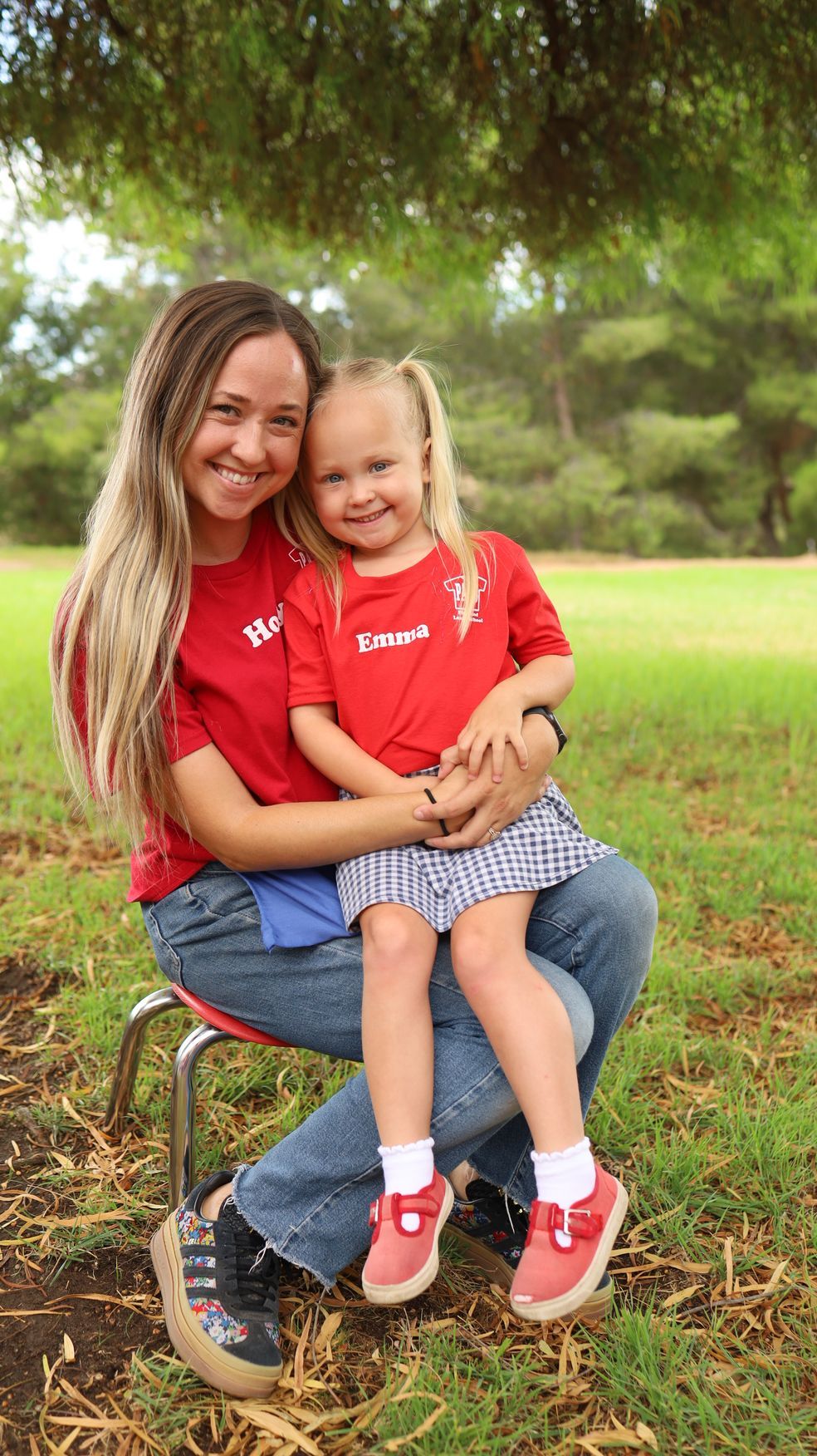 A woman is holding a little boy in her arms in a park.
