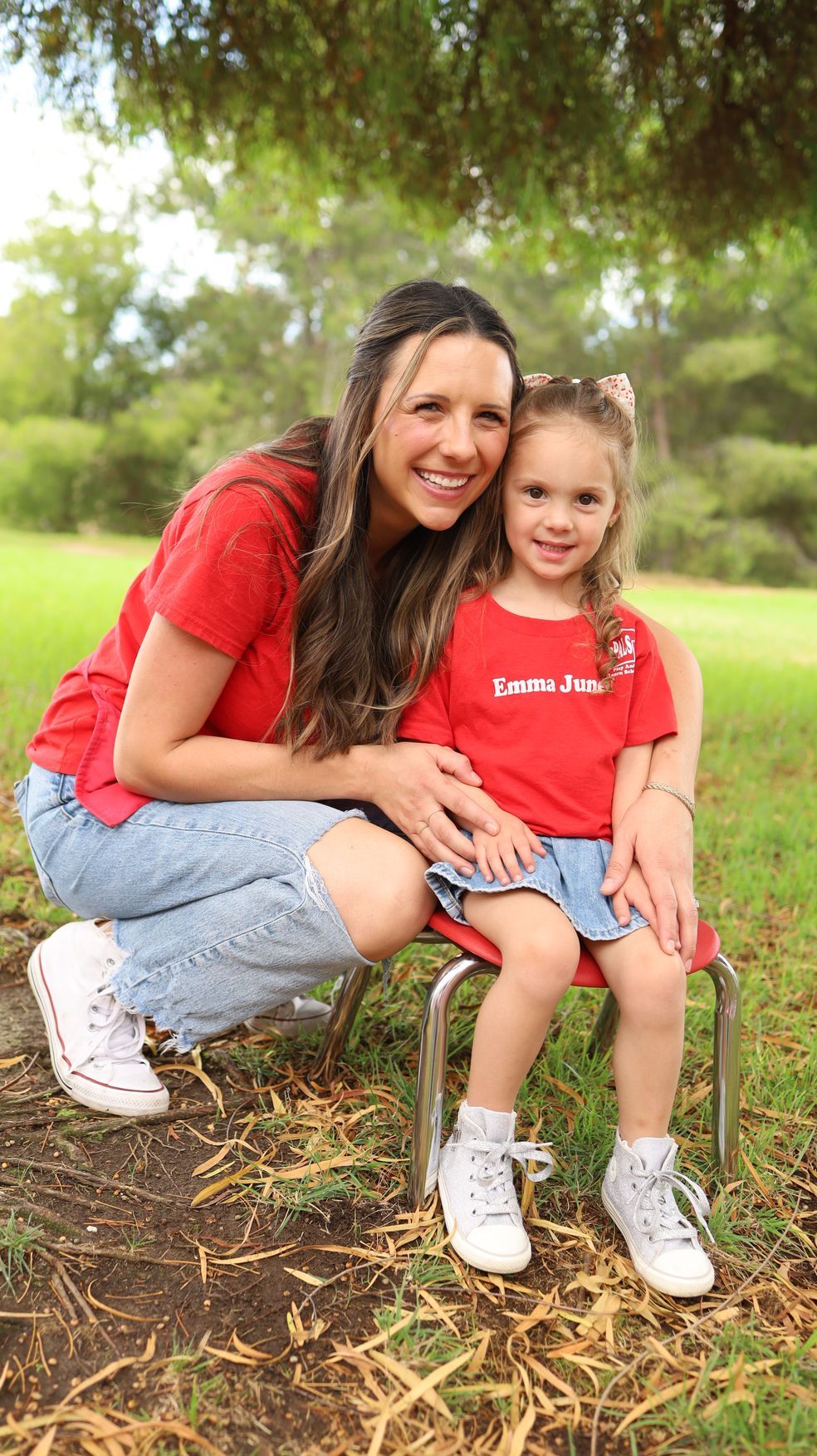 A woman is holding a little boy in her arms in a park.