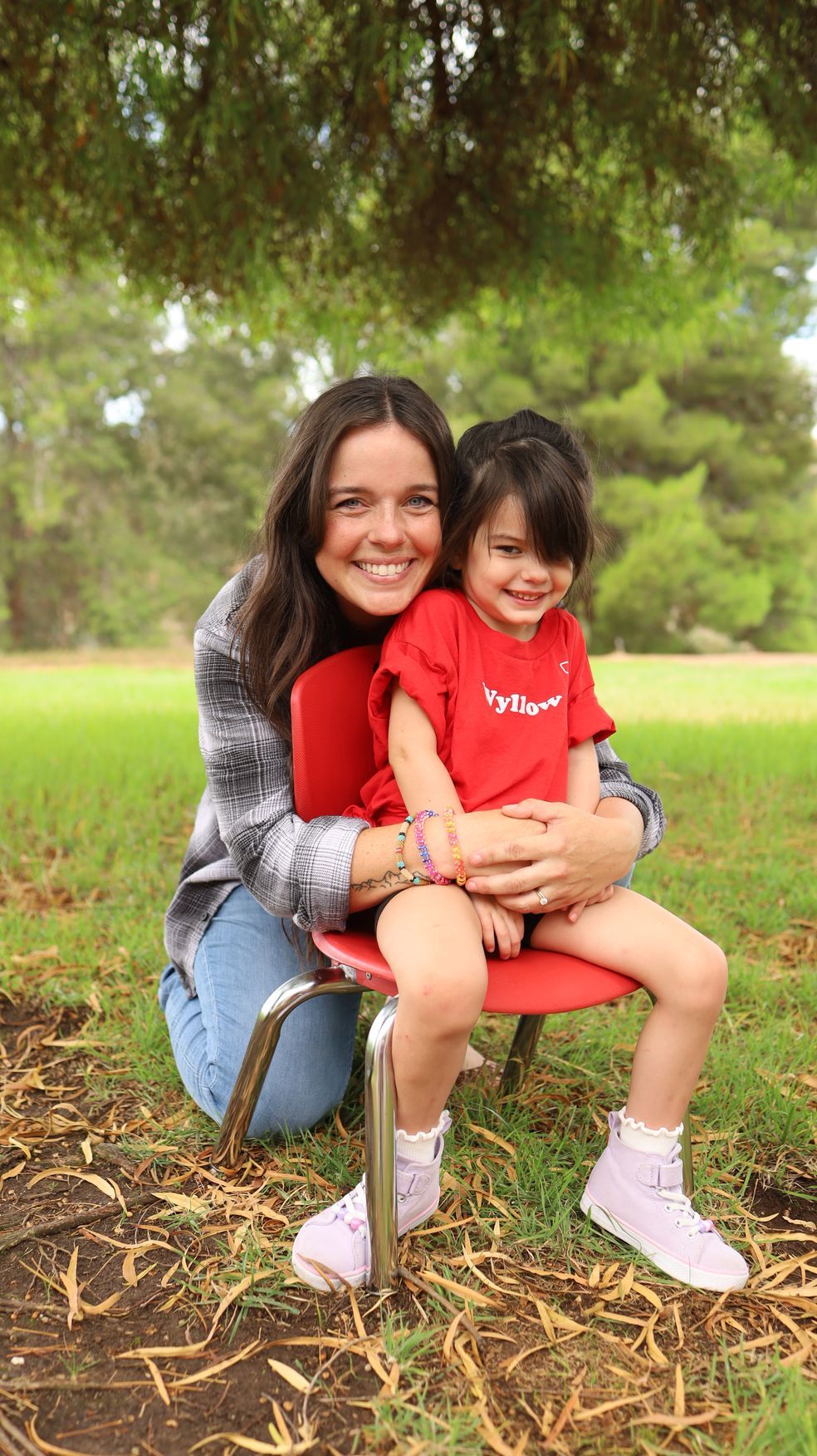A woman is holding a child in her arms in a park.