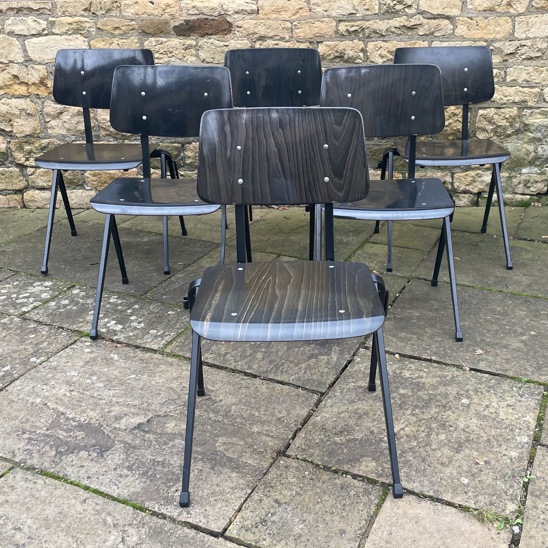 6 stacking chairs made of resin with metal frames.