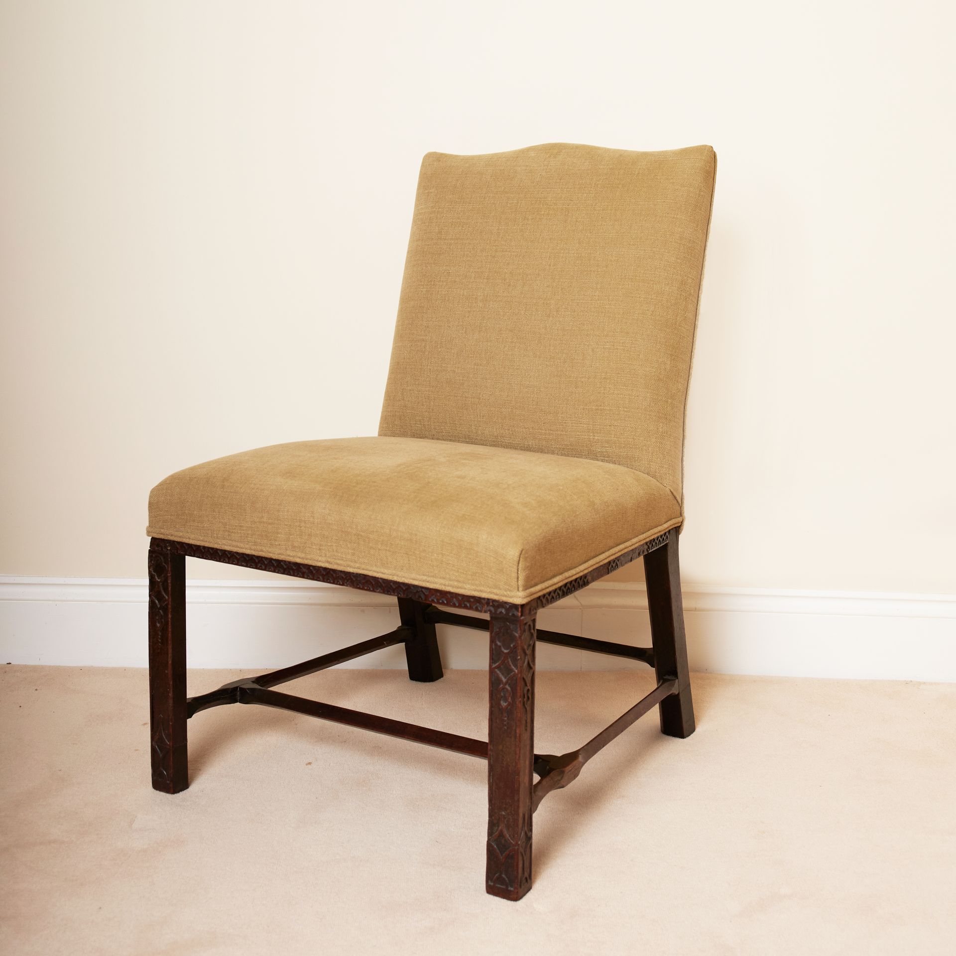 An antique armless chair re-upholstered in raw silk.