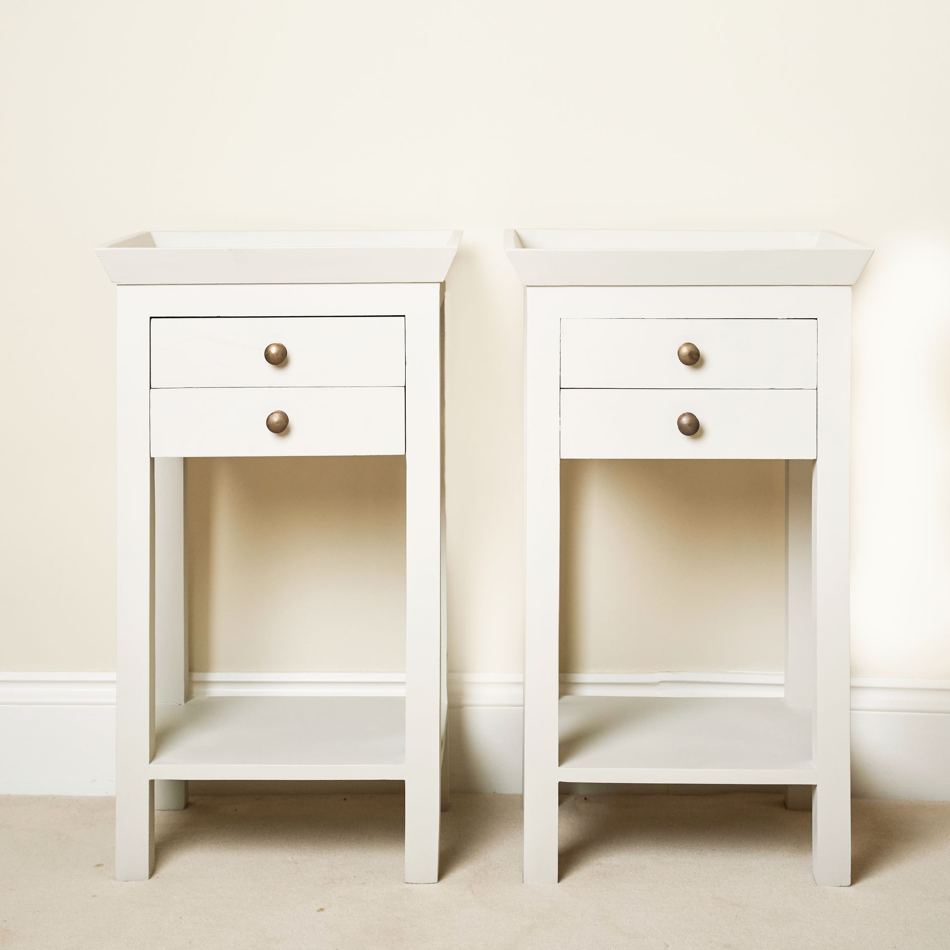 2 rectangular night stands with a low shelf and 2 high drawers and a raised lip to the tabletop.