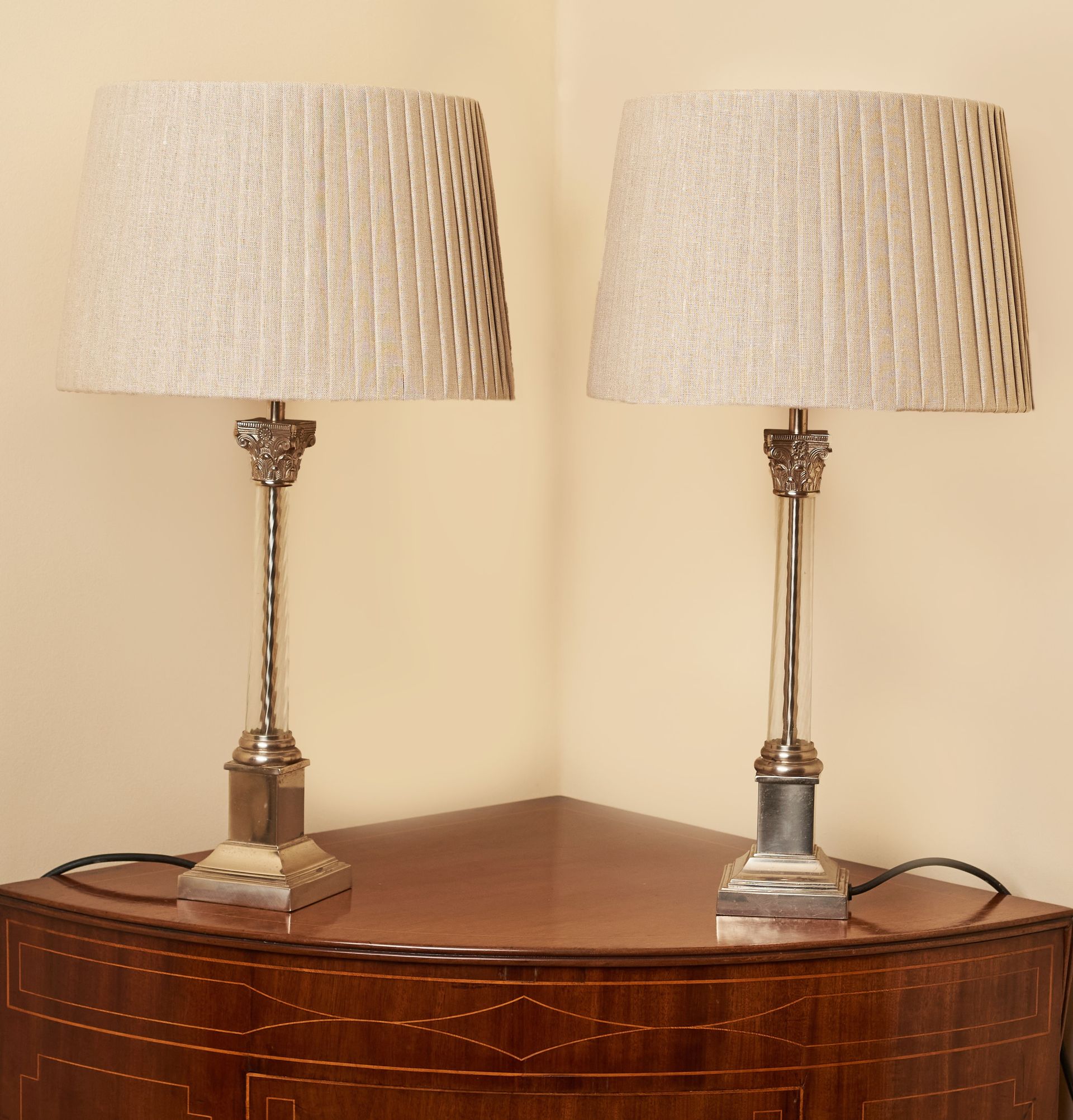 2 vintage lamps with twisted glass columns and silver bases.