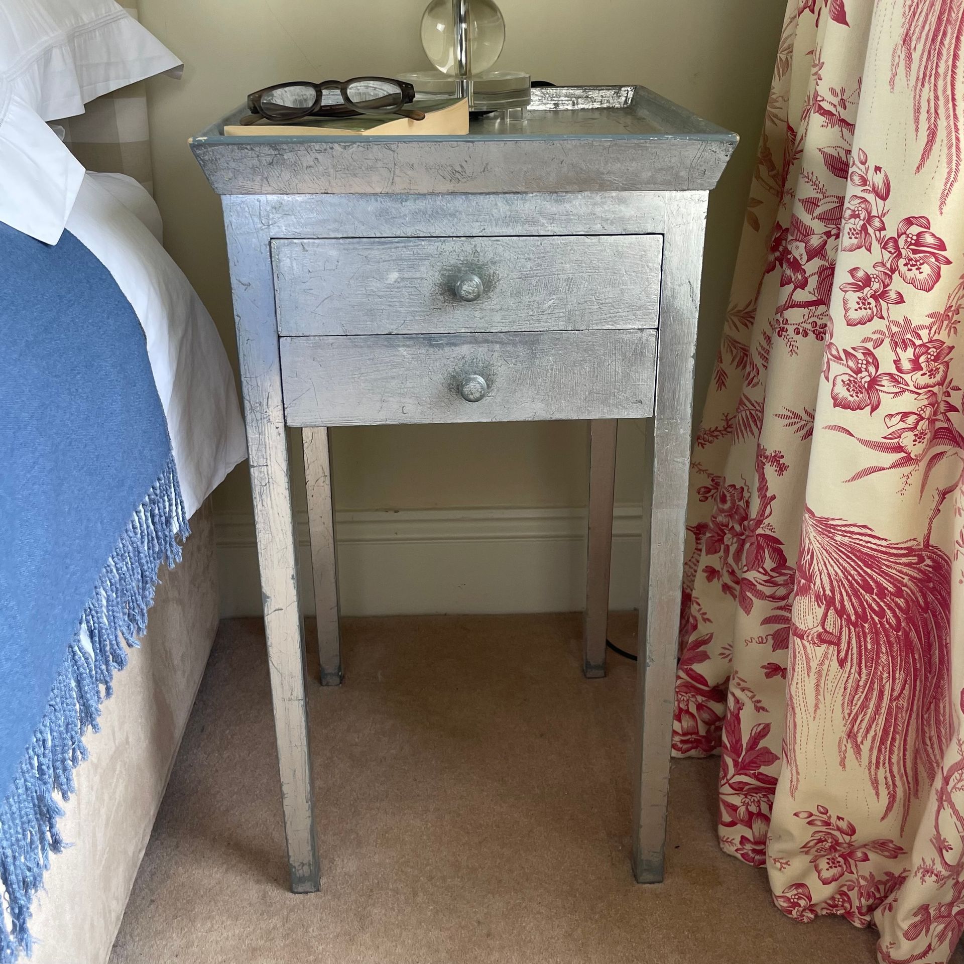 Silver bedside table with long legs and 2 small drawers.