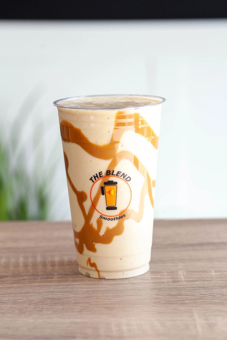 Caramel-swirled smoothie in a plastic cup with