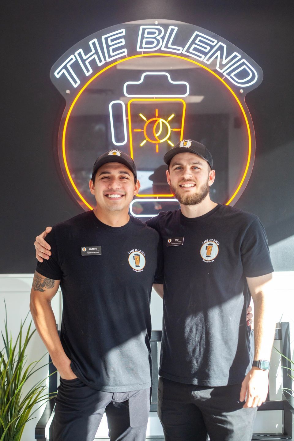 Two men smiling, arm-in-arm, in front of a