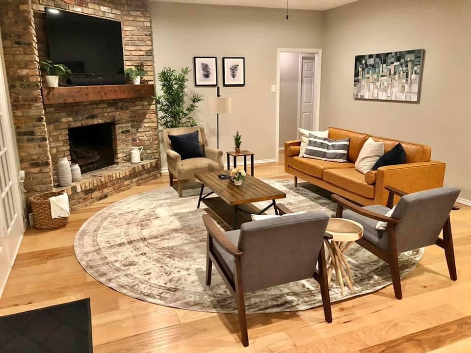 A living room with a couch , chairs , and a fireplace.