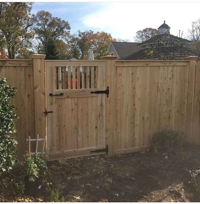 A wooden fence with a gate in the backyard.