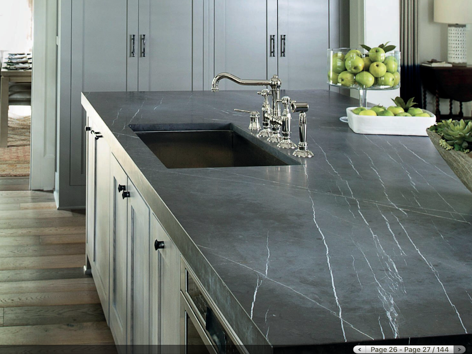 A kitchen with a stove top oven and a brick wall.