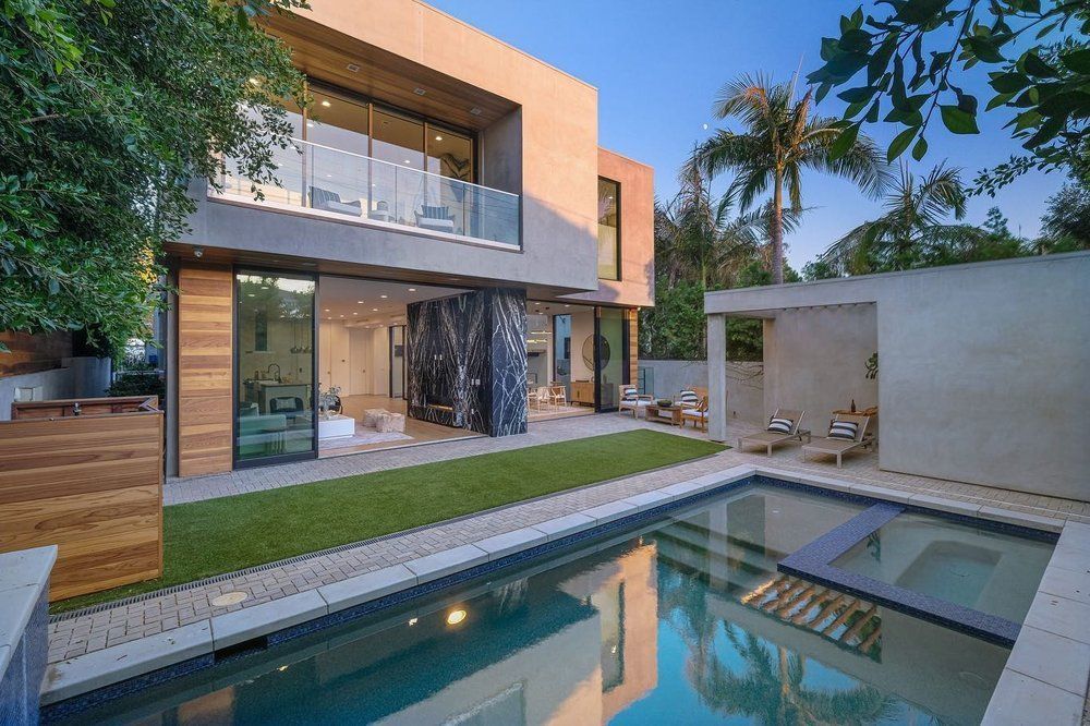 A large house with a swimming pool in front of it