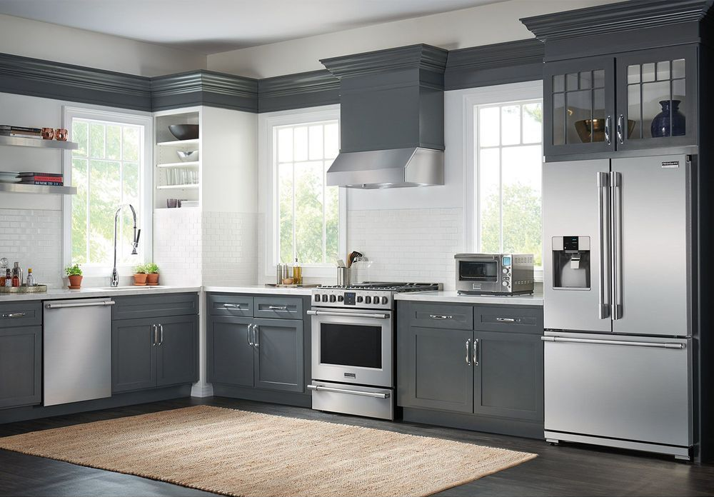 Gray and white kitchen with stainless steel appliances and rug.