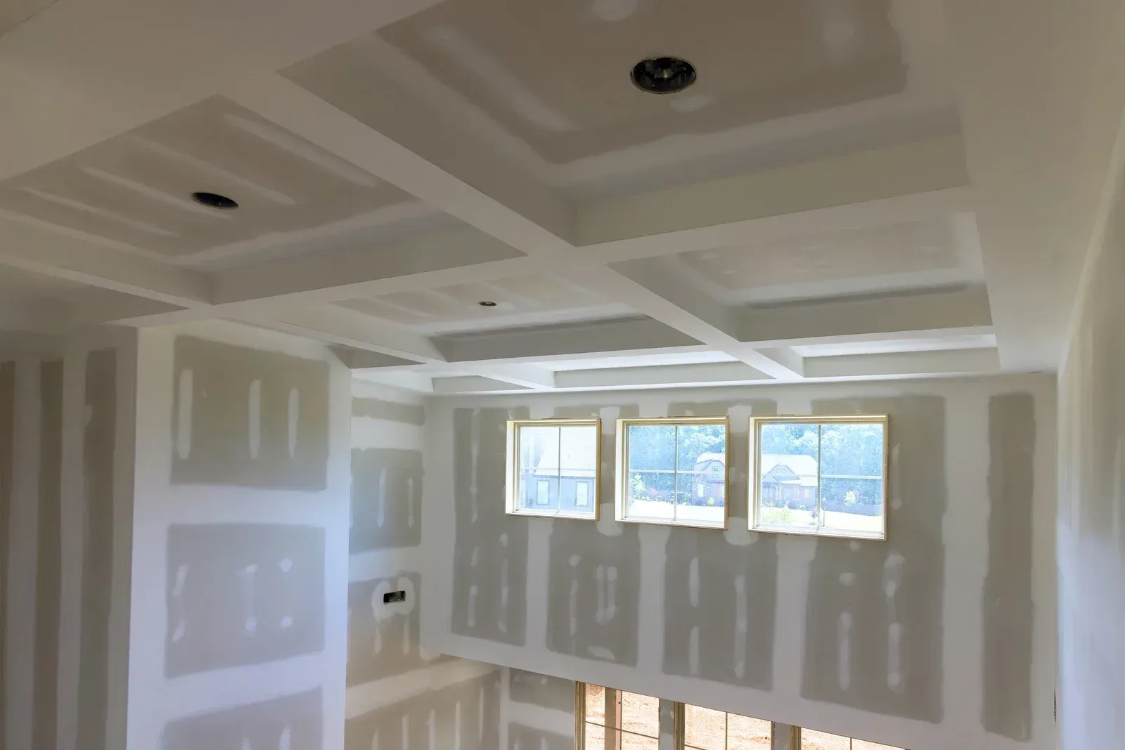 Interior construction: Drywall installed on ceiling with recessed design and walls, and around windows.