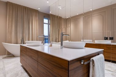 Modern bathroom with wood vanity, freestanding tub, large mirror, and beige curtains
