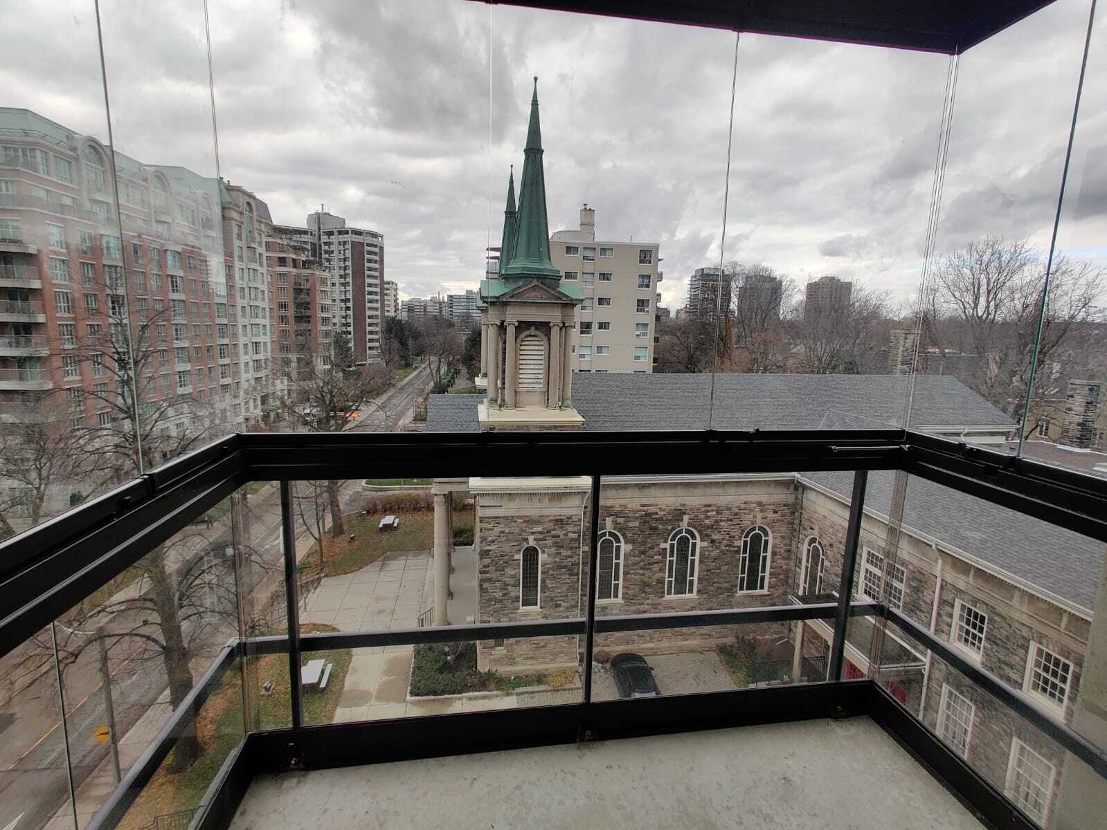 View from a balcony overlooking a church and city buildings. Gray overcast sky.