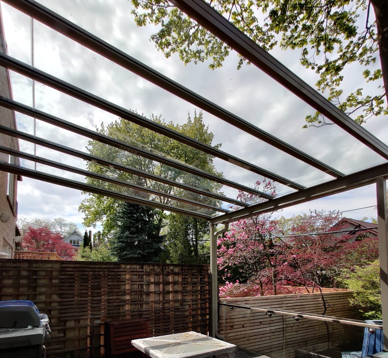A patio with a table and chairs under a clear roof