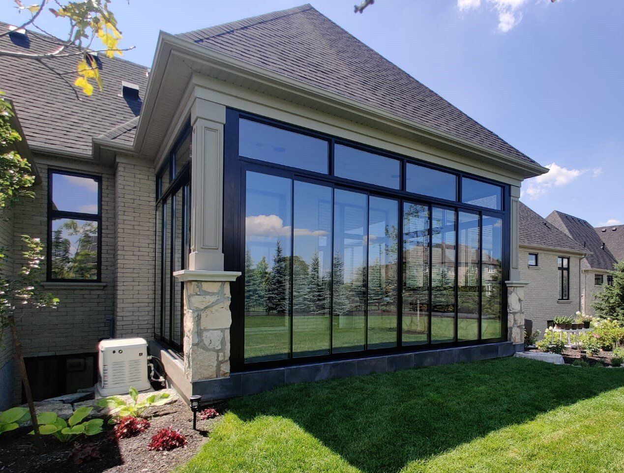 A house with a sunroom with a lot of windows on the side of it.