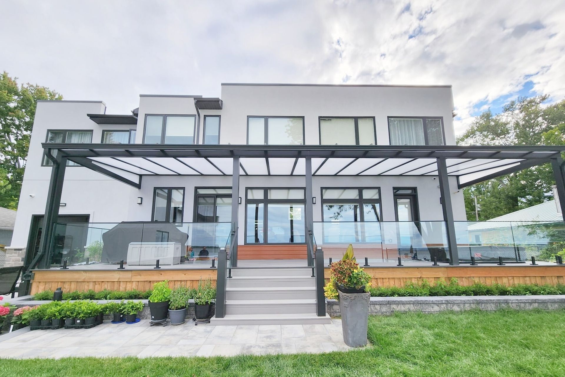 Person on ladder working on the balcony of a high-rise building, using a safety harness.
