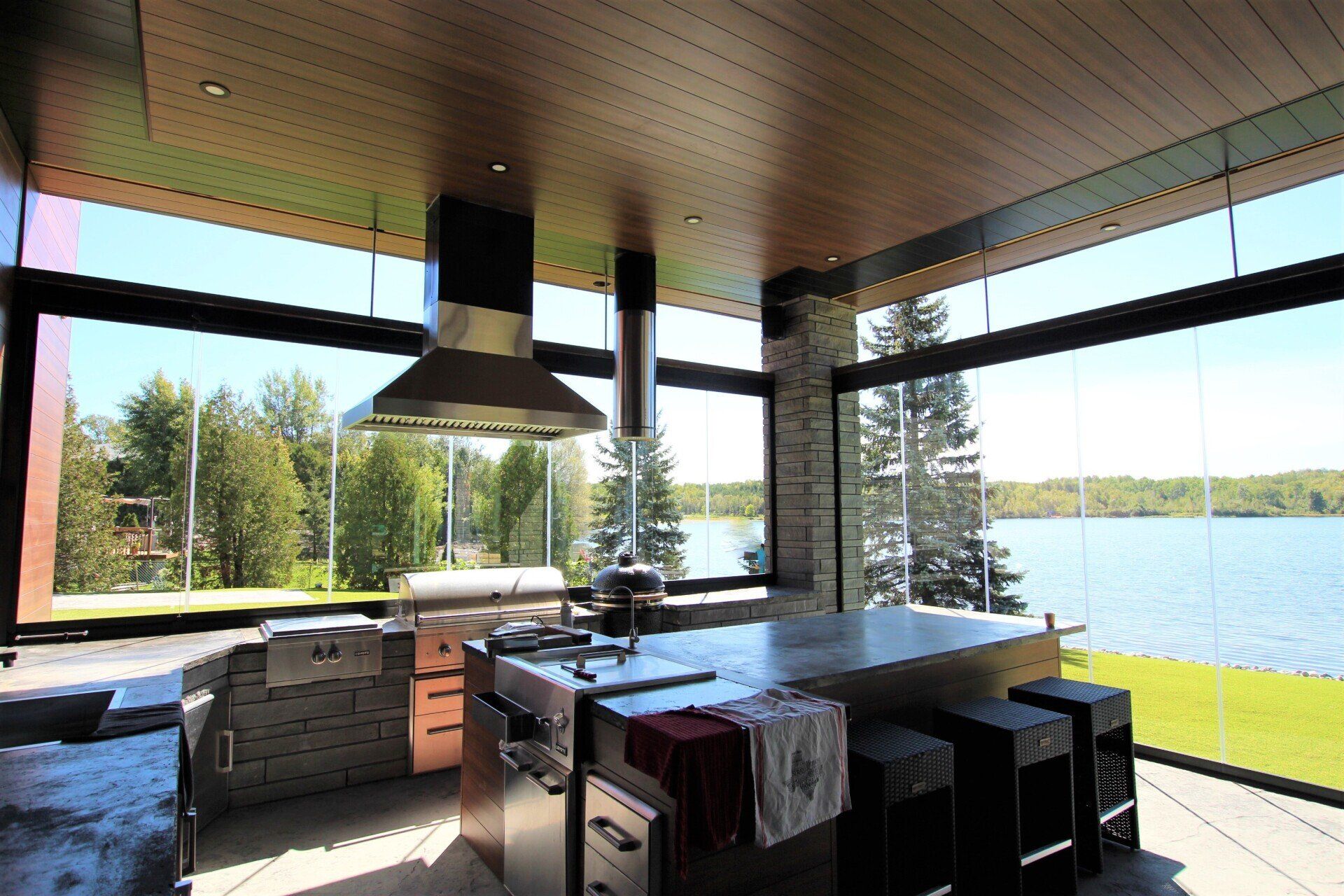 A kitchen with a large island and a large window overlooking a lake