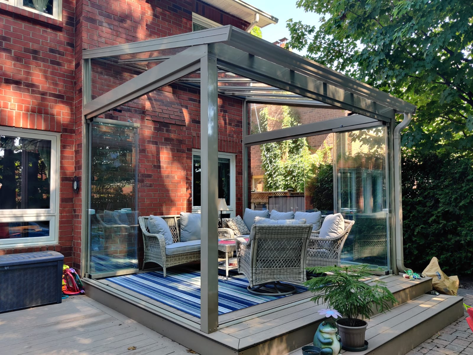 A patio with a couch and chairs under a canopy.