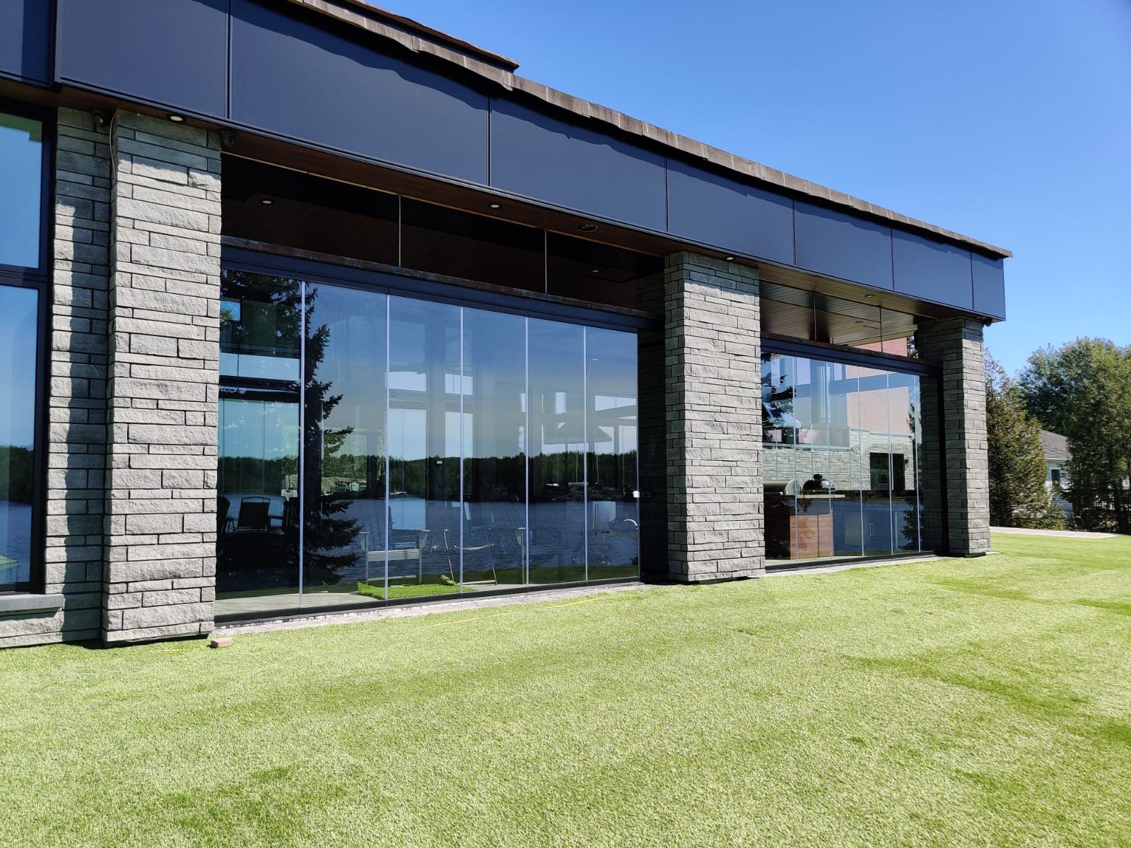 A large building with a lot of windows is sitting on top of a lush green field.