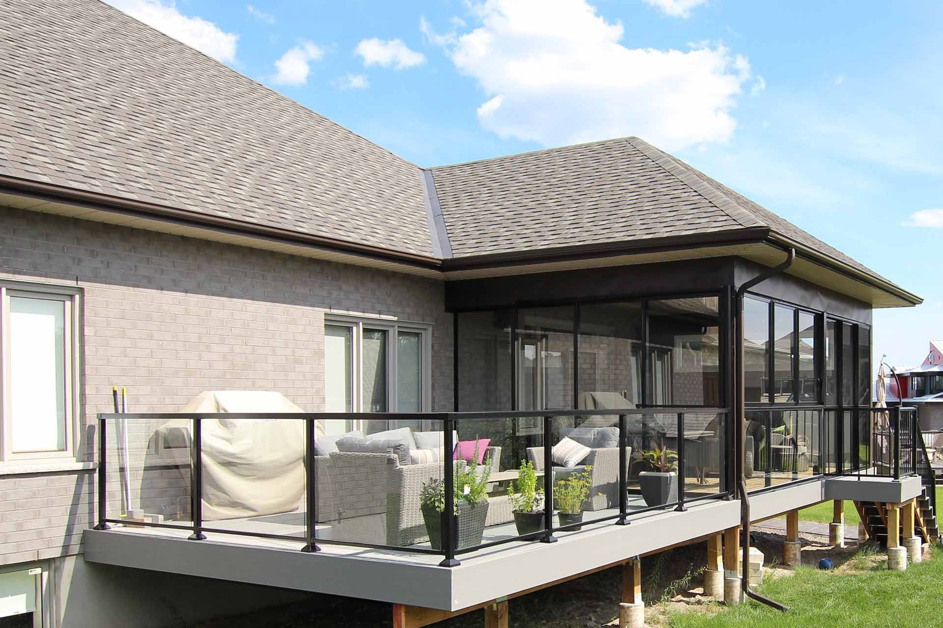 A house with a large deck and a screened in porch.