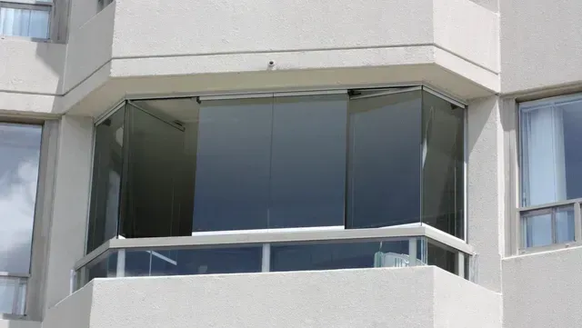 A balcony on the side of a building with sliding glass doors