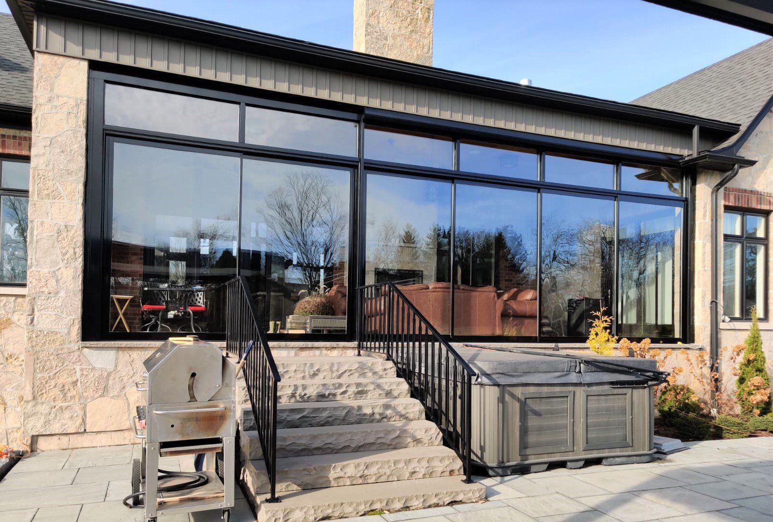 A house with a hot tub and a grill in front of it.