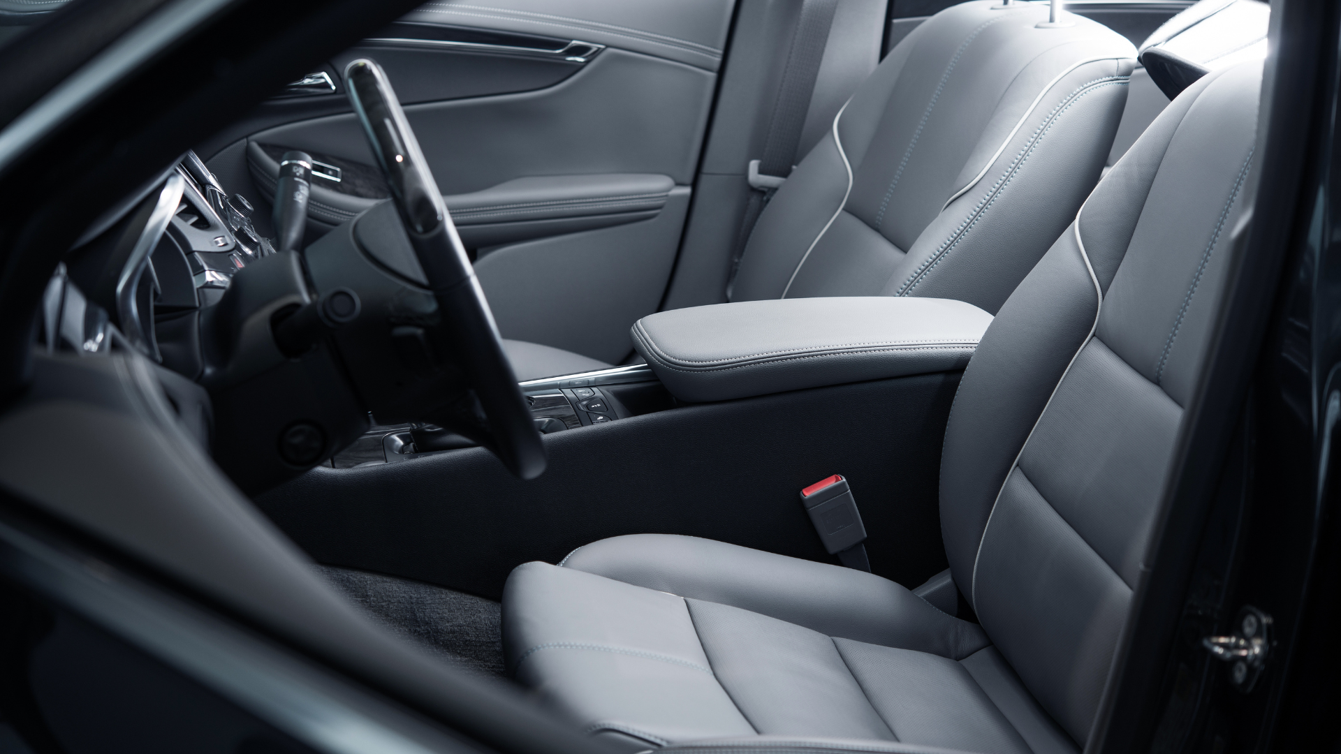 Gray car interior with front seats, center console, and steering wheel visible